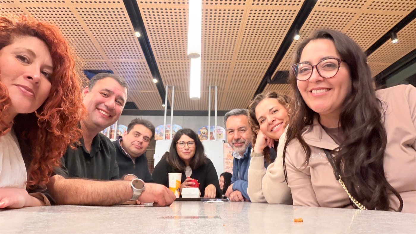 El equipo sonriendo junto a una mesa