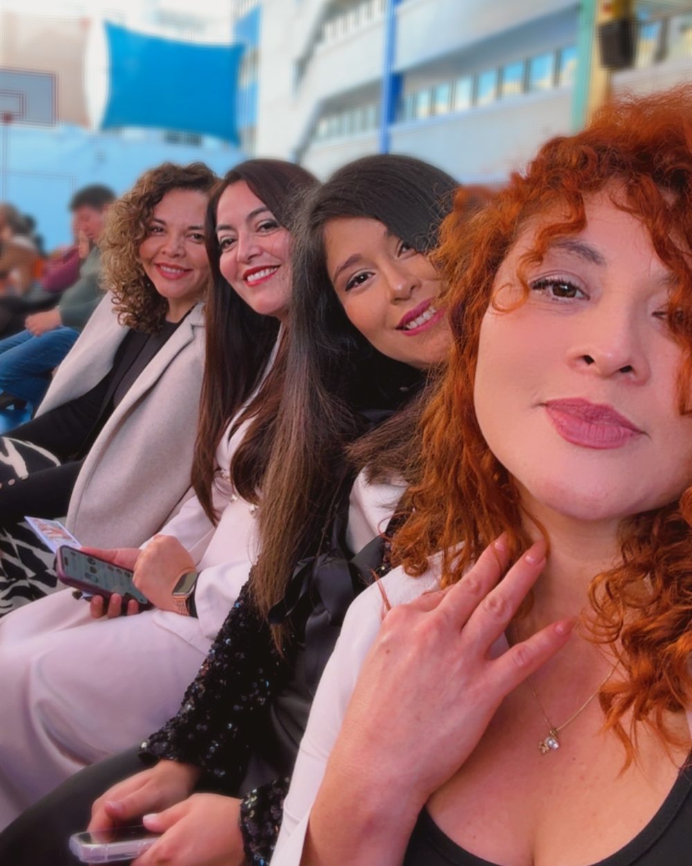 Las cuatro integrantes sentadas juntas, sonriendo